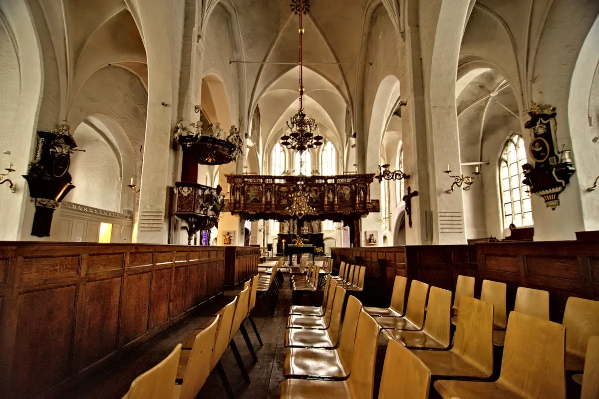 kirche innenraum mit stuhlreihen und goldverziertem hochaltar