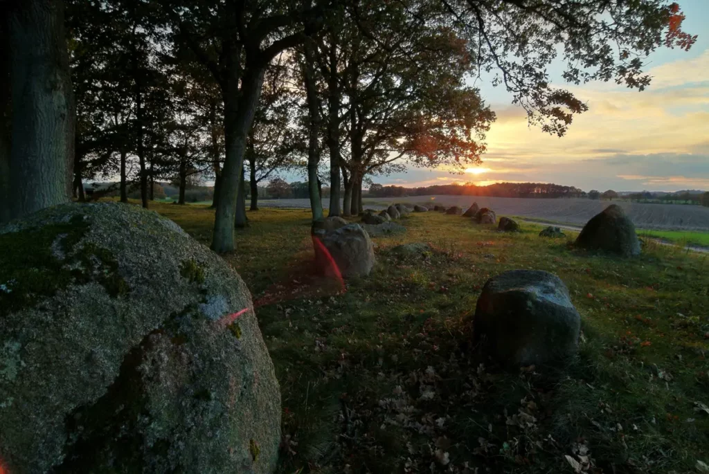 sonnenuntergang an steingräbern im wald