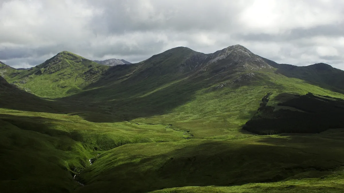 grüne hügel unter wolkigem himmel in irland