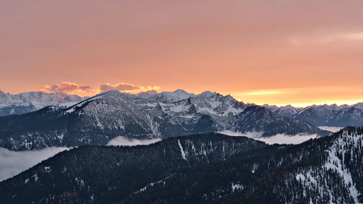 sonnenuntergang über schneebedeckten bergipfeln
