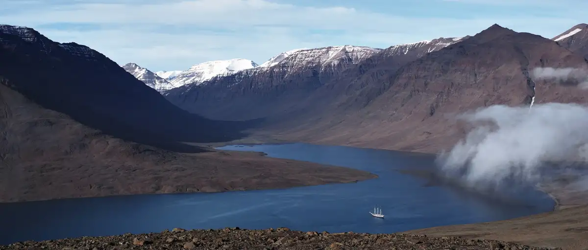 segelschiff rembrandt van rijn in fjord zwischen steilen schneebedeckten bergen
